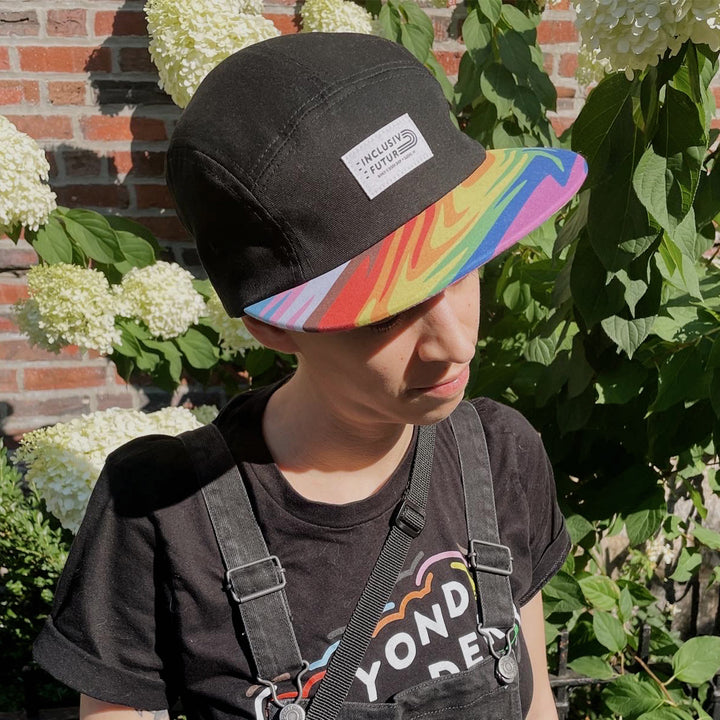 Model wearing the Inclusive Future Pride Camper Hat by Bianca Designs.
