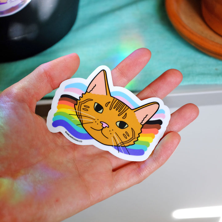 Hand holding the Jade Cat Rainbow Sticker by Bianca Designs