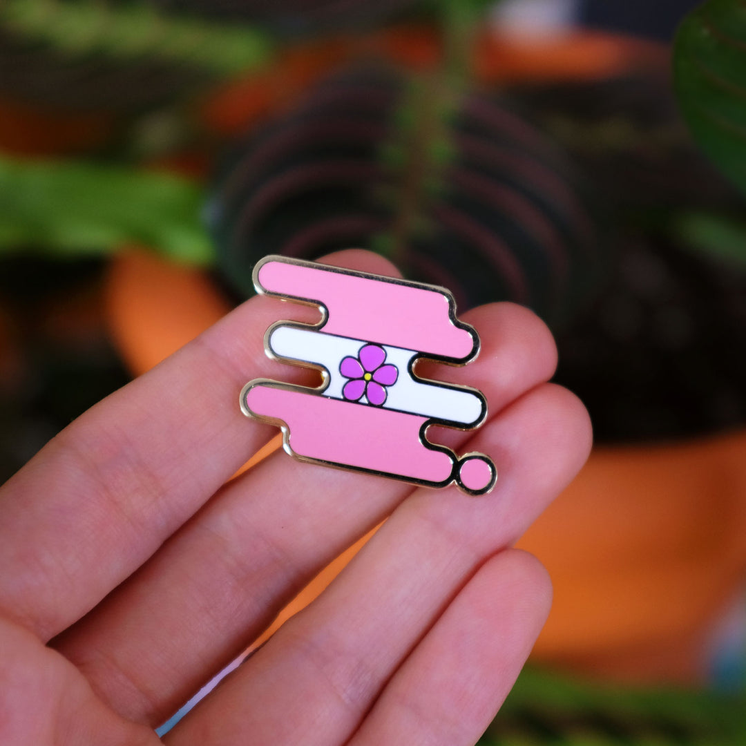 Hand holding the Sapphic Pride Enamel Pin by Bianca Designs.