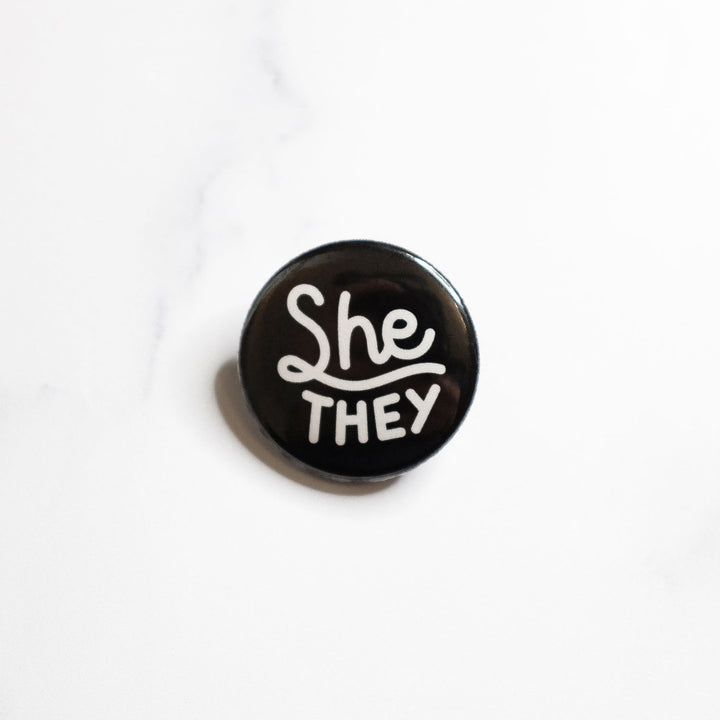 She/they Pronouns Button by Bianca Designs.