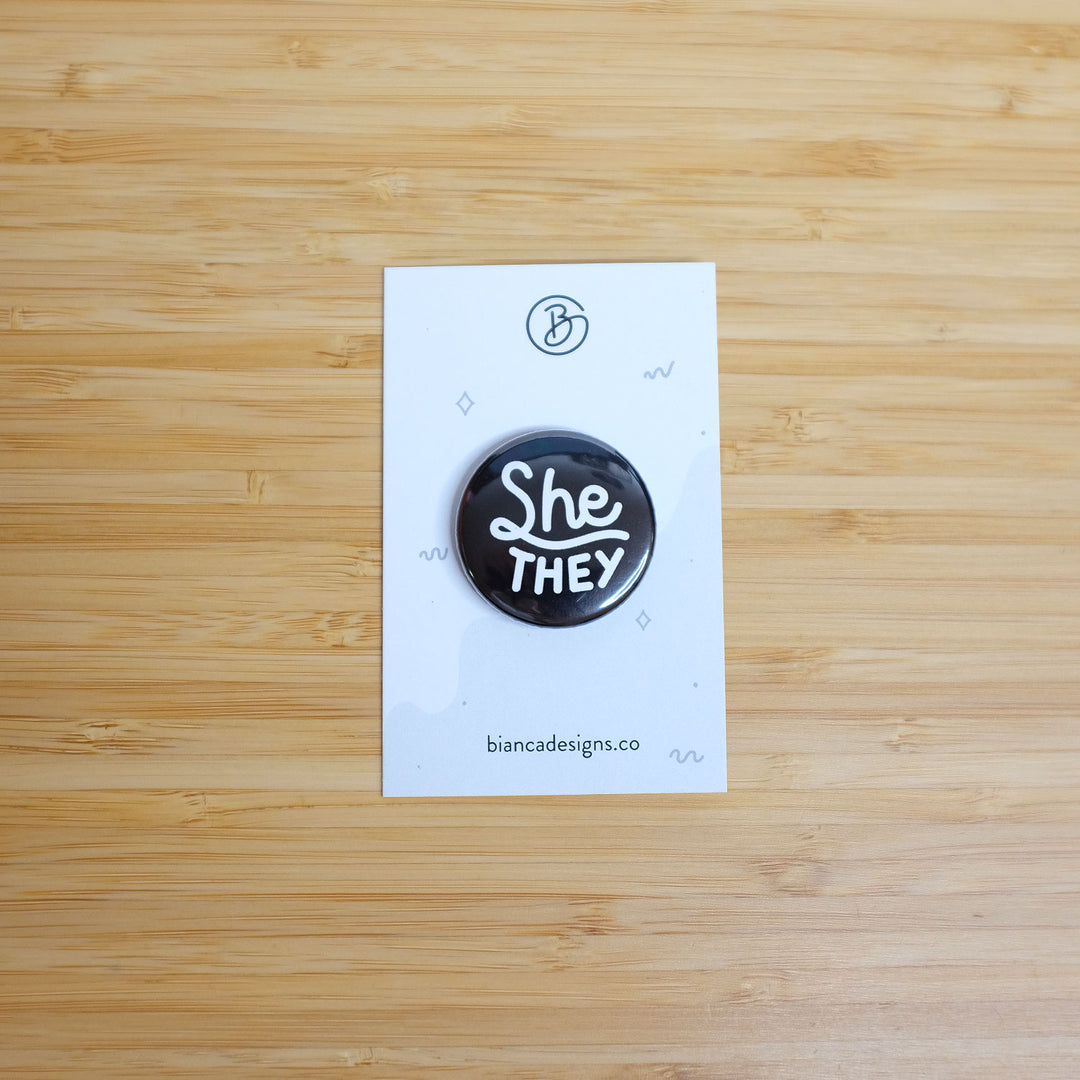 She/they Pronouns Button on a Backer Card by Bianca Designs.