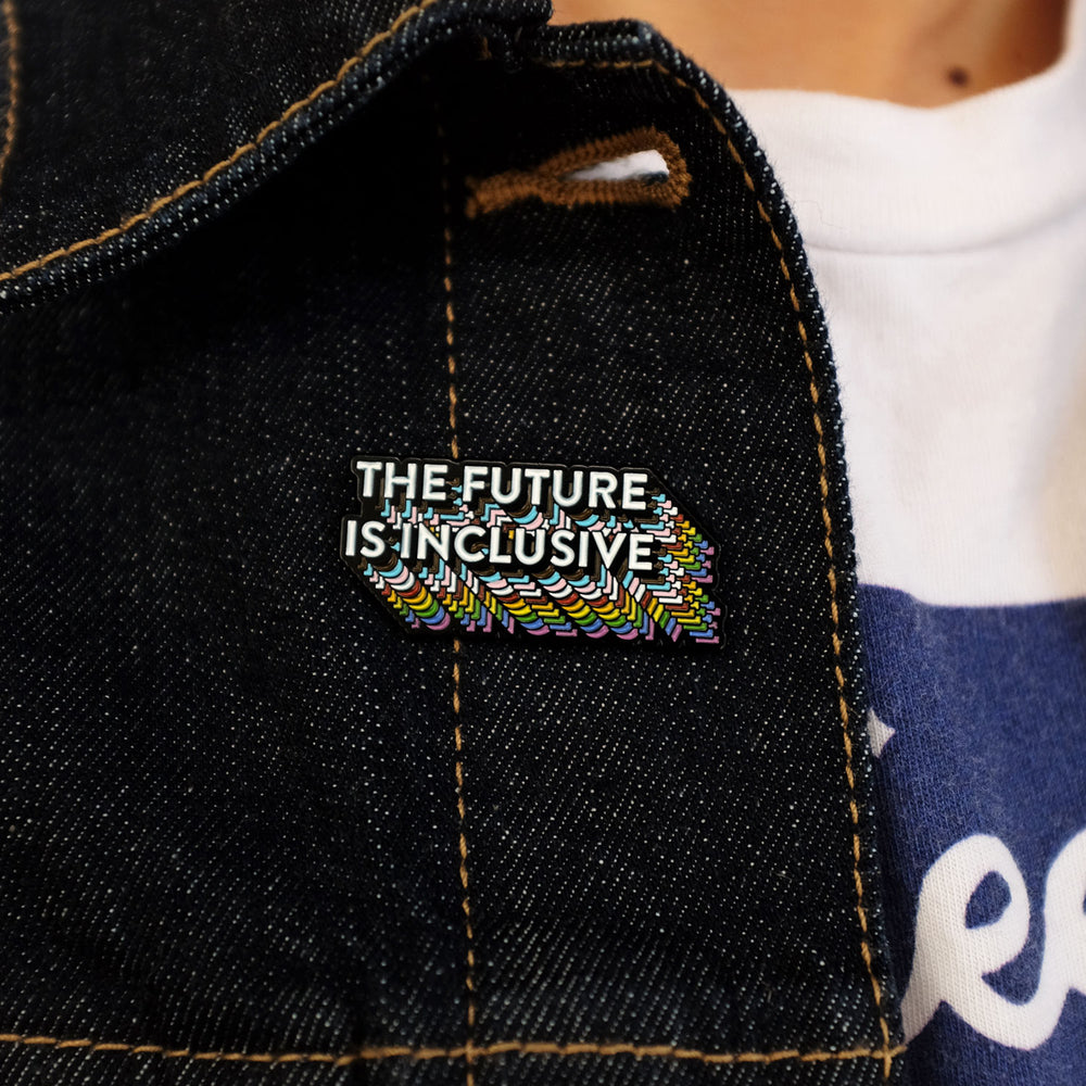 The Future Is Inclusive Rainbow Pride Enamel Pin, pinned to a denim jacket, by Bianca Designs