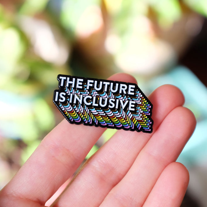 Hand holding The Future Is Inclusive Rainbow Pride Enamel Pin by Bianca Designs