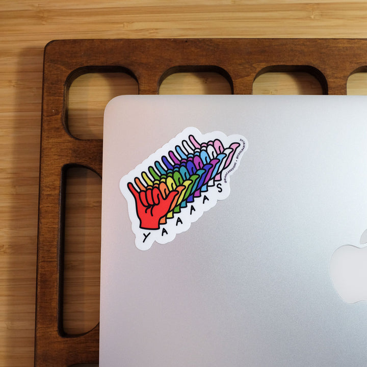 Yaaaas in ASL Sticker by Bianca Designs and Gregor Lopes. Sticker is displayed on a laptop.